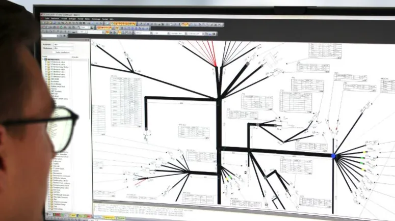 Ingenieur vor einem Bildschirm mit einer Kabelbaumzeichnung im E-CAD-Programm